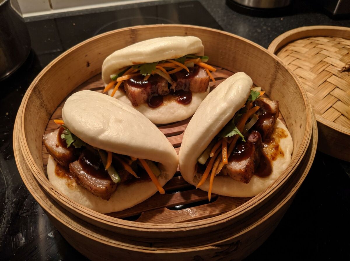 Tři bao buns s bůčkem a nakládanou zeleninou v bambusovém košíku